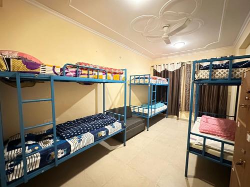 Mixed dorm with blue metal bunk beds, colourful blankets, and a privacy curtain